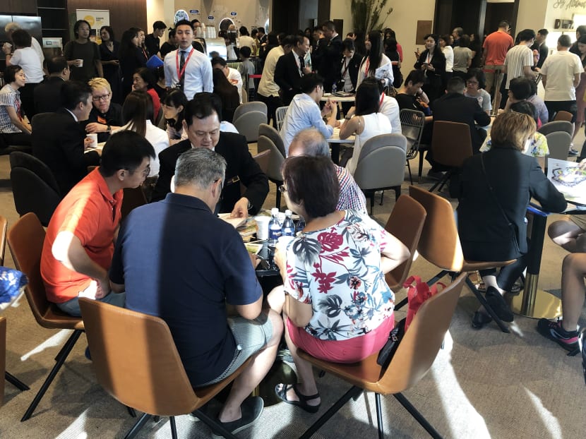 Mr Alex Poh, chairman of Pearl Bank Apartments’ collective sales committee, guiding his former neighbours (in the foreground) in their potential purchases at the new One Pearl Bank condominium sales gallery's opening day on July 13, 2019. Photo: Wong Pei Ting