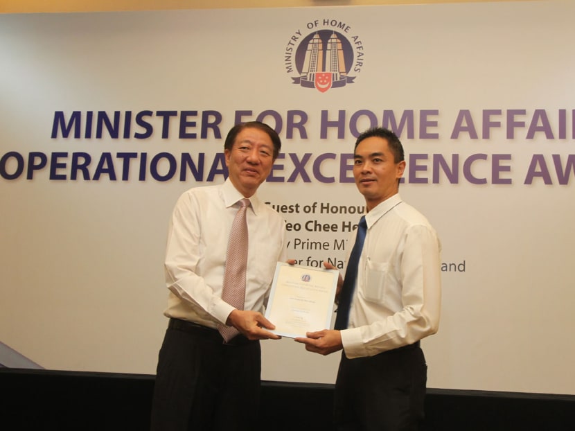 Deputy Prime Minister Teo Chee Hean presents DAC Adrian Quek with the Home Affairs Operational Excellence Award on Jan 15, 2014. Photo: Ooi Boon Keong