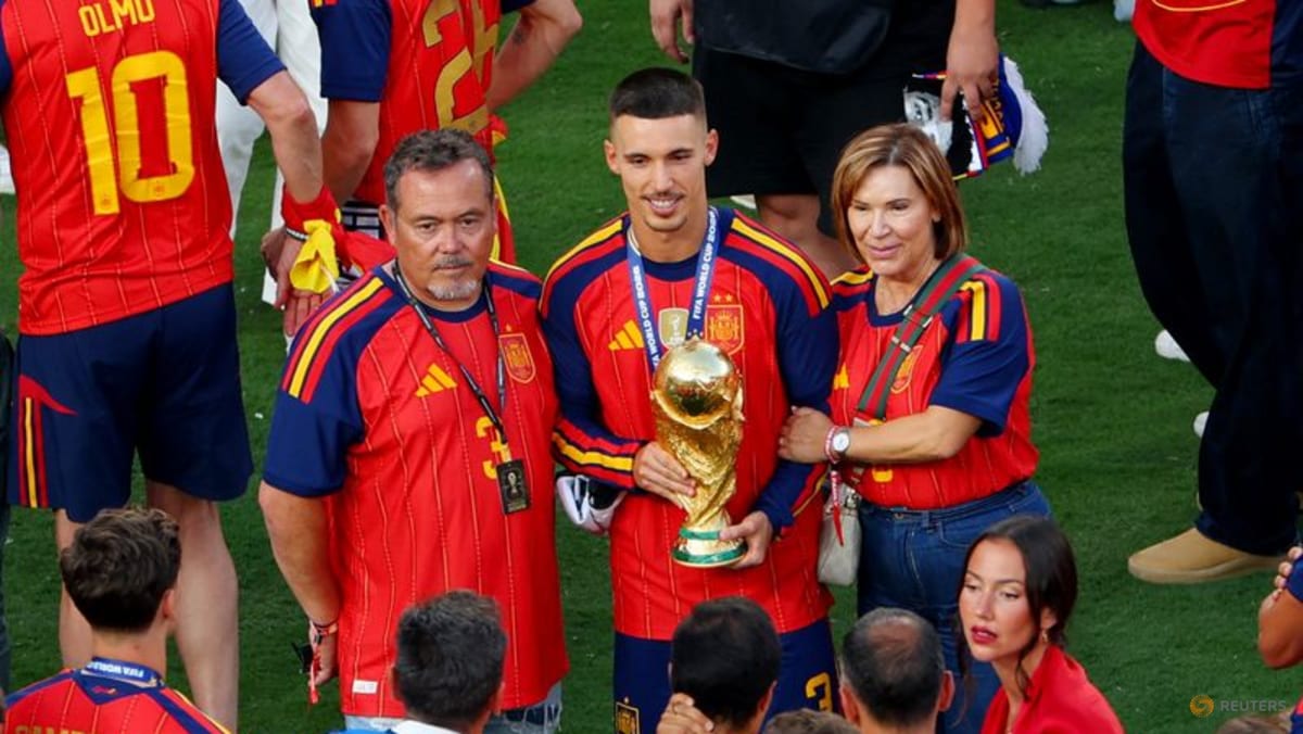 Soccer Football - FIFA World Cup 2026 - Final - Spain v Argentina - New York/New Jersey Stadium, East Rutherford, New Jersey, U.S. - July 19, 2026 Spain's Alex Grimaldo with the World Cup trophy as he celebrates winning the World cup with father Miguel Grimaldo and his mother REUTERS/Mike Segar