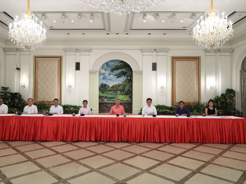Prime Minister Lee Hsien Loong, flanked by seven political office holders, during a briefing on Saturday (July 25) to unveil the latest Cabinet line-up. Prime Minister Lee Hsien Loong, flanked by seven political office holders, during a briefing on Saturday (July 25) to unveil the latest Cabinet line-up.