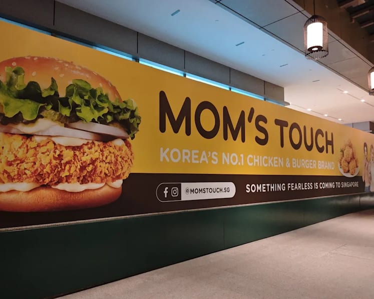 Korean fast food chain Mom's Touch returning to Singapore, banner with K-pop group Le Sserafim seen at Chinatown