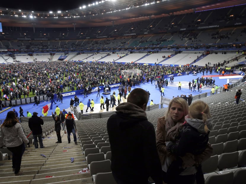 Supporters invade the pitch of the Stade de France stadium at the end of the international friendly soccer match between France and Germany in Saint Denis, outside Paris. Hundreds of people spilled onto the field of the Stade de France stadium after explosions were heard nearby. French President Francois Hollande says he is closing the country's borders and declaring a state of emergency after several dozen people were killed in a series of unprecedented terrorist attacks. (AP Photo/Christophe Ena)