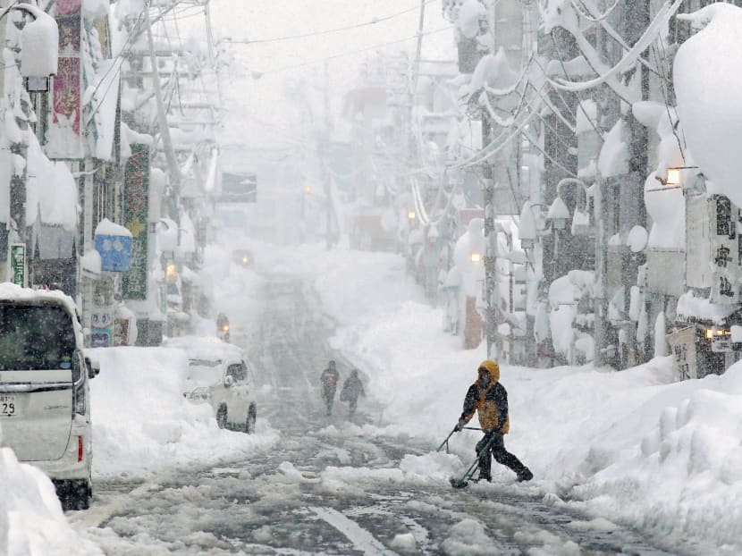 People remove snow on a street in Yuzawa, Niigata Prefecture, Japan in this photo taken by Kyodo on Thursday, Dec 17, 2020. People remove snow on a street in Yuzawa, Niigata Prefecture, Japan in this photo taken by Kyodo on Thursday, Dec 17, 2020.