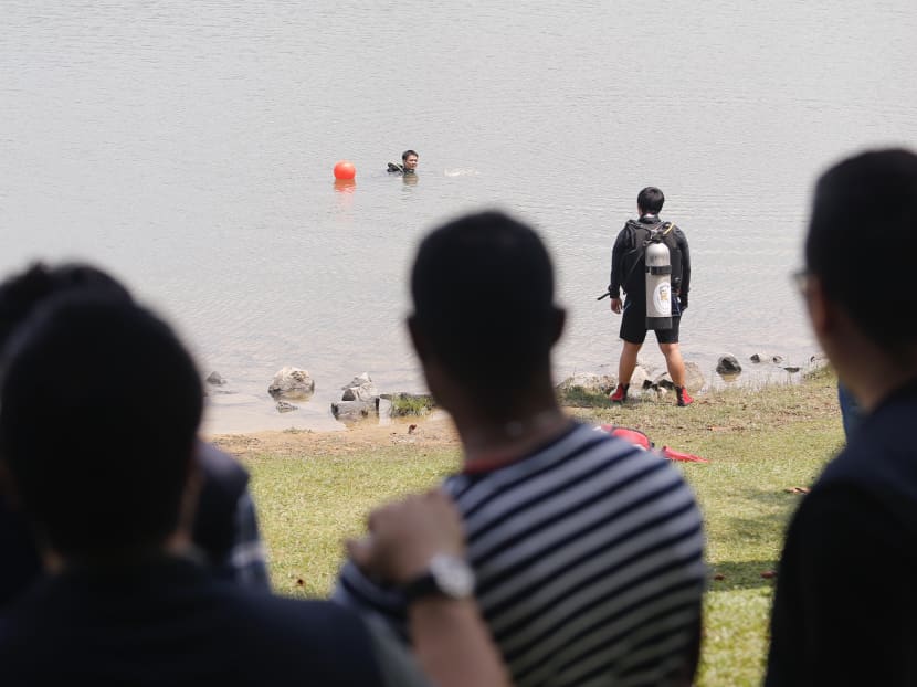 Police and a suspect in the Serangoon slashing incident watch on, as divers enter the Lower Pierce Reservoir in search for a samurai sword reportedly used in the attack.
