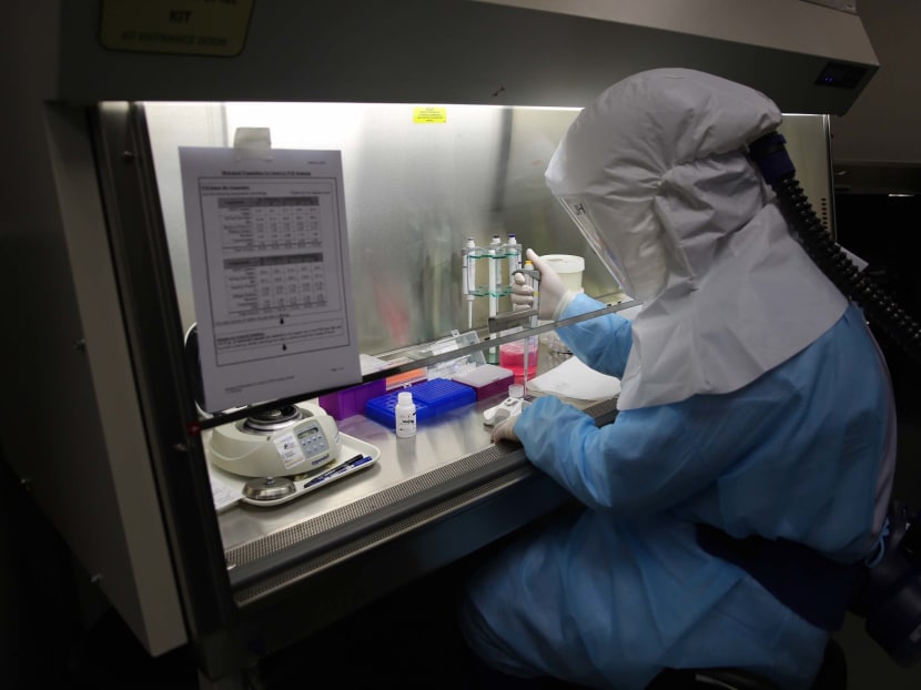 A scientist processing samples to screen and detect the Sars-CoV-2 coronavirus that is responsible for Covid-19 at a laboratory.