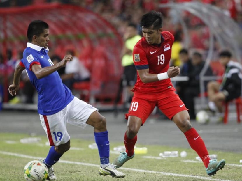 Singapore's Khairul Amri (in red) contesting with Malaysia's Azammuddin bin Mohd Akilat the AFF Suzuki Cup 2014 on 29 Nov 2014. Photo: Wee Teck Hian