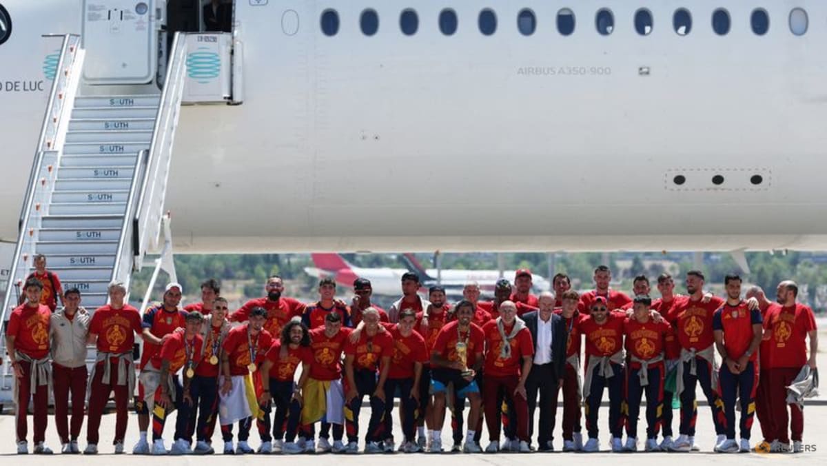 Soccer Football - FIFA World Cup 2026 - Spain players return to Madrid after winning the World Cup - Madrid, Spain - July 20, 2026 Spain players players pose for a team group photo with the World Cup trophy during the team's arrival at Madrid (Ảnh: CNA)