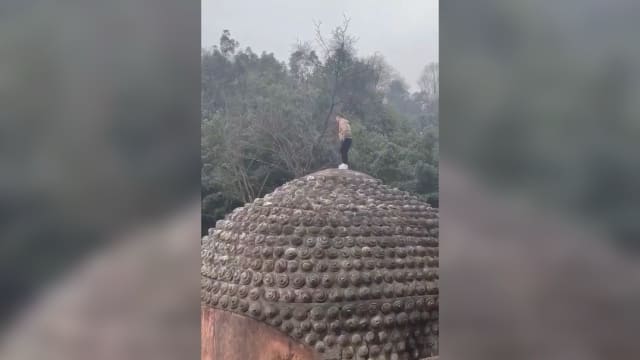 男子翻越围栏 爬上乐山大佛头顶撒尿
