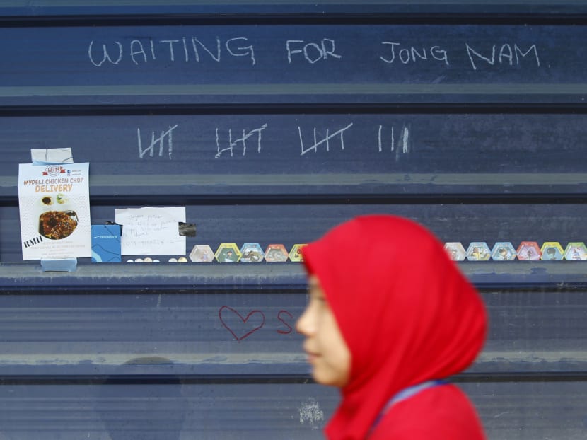 A woman walk pass the wall stated the day of coverages by the media in front forensic department at Kuala Lumpur Hospital in Kuala Lumpur, Malaysia on Thursday, March 2, 2017. Photo: AP