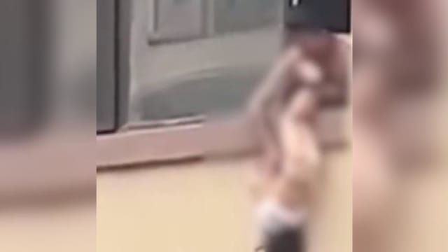 女孩家中乱小便 中国父亲将她倒挂墙外责罚