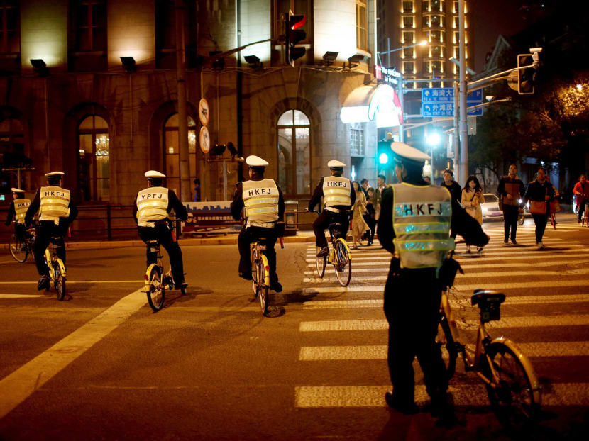 Security officers riding bicycles of bike-sharing company Ofo on a street in Shanghai, China, on Saturday. A fatal accident involving an Ofo bike and an 11-year-old boy in Shanghai on Sunday was the first known deadly traffic incident involving an under-aged bike-sharing user. Photo: Reuters