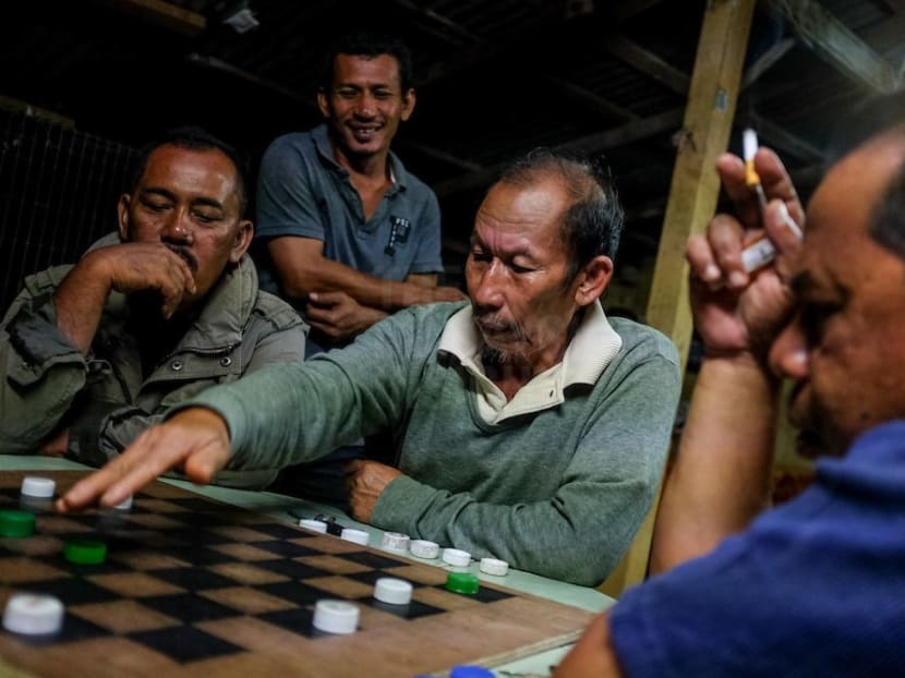 Kampung Kok Majid villagers playing chequers after Isyak prayers. This is one of the few entertainment activities not banned by the Kelantan state government.