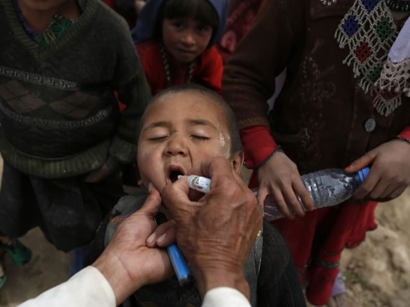 An Afghan child receives polio vaccination drops near the site of a landslide at the Argo district in Badakhshan province, May 4, 2014.  Photo: Reuters