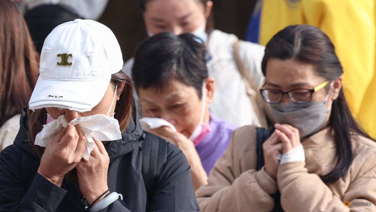 Grieving Hong Kong families search stark photos for fire victims