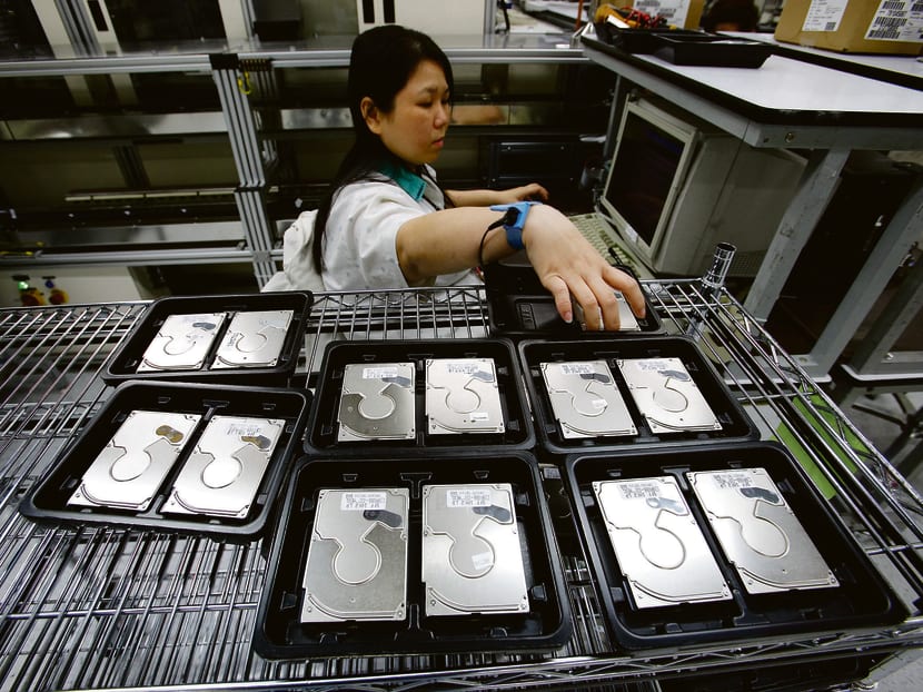 A Seagate Technology employee tests hard disk drives at the company’s disk drive assembly plant in Singapore. Bloomberg file photo