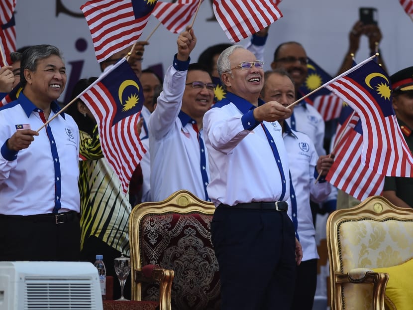Malaysia's Prime Minister Najib Razak (right) and his deputy Ahmad Zahid Hamidi (left) wave national flags during the 59th National Day celebrations at Independence Square in Kuala Lumpur on Aug 31, 2016.  Photo: AFP