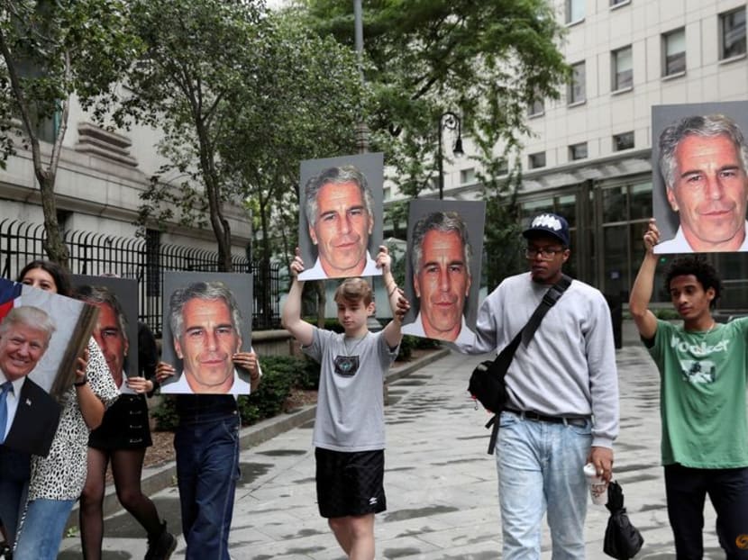 FILE PHOTO: Demonstrators hold signs aloft protesting Jeffrey Epstein, as he awaits arraignment in the Southern District of New York on charges of sex trafficking of minors and conspiracy to commit sex trafficking of minors, in New York, U.S., July 8, 2019. REUTERS/Shannon Stapleton/File Photo
