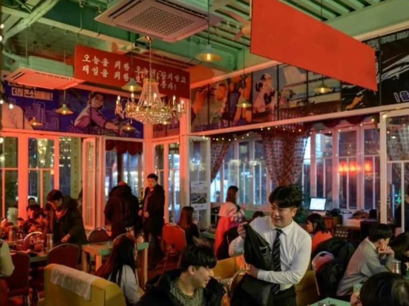 The premises are festooned with North Korean-style posters, the lime green walls reminiscent of the pastel shades seen on Pyongyang apartment blocks, and slogans painted around the pub are written in a white-on-red script similar to the North's propaganda.