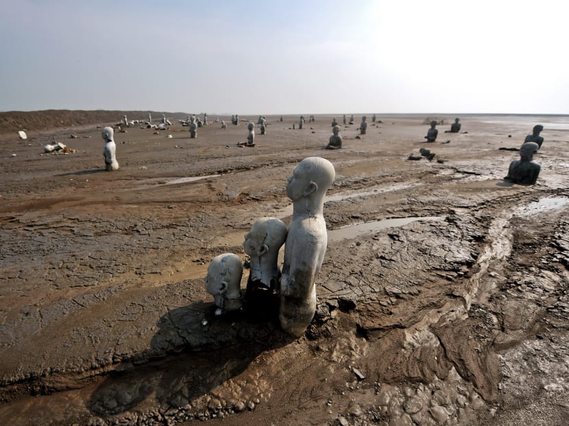 Statues stand semi-submerged at a mud volcano area in Sidoarjo in East Java. An area roughly equivalent to 650 football fields is now buried ­beneath up to 40m of sludge. Photo: AFP