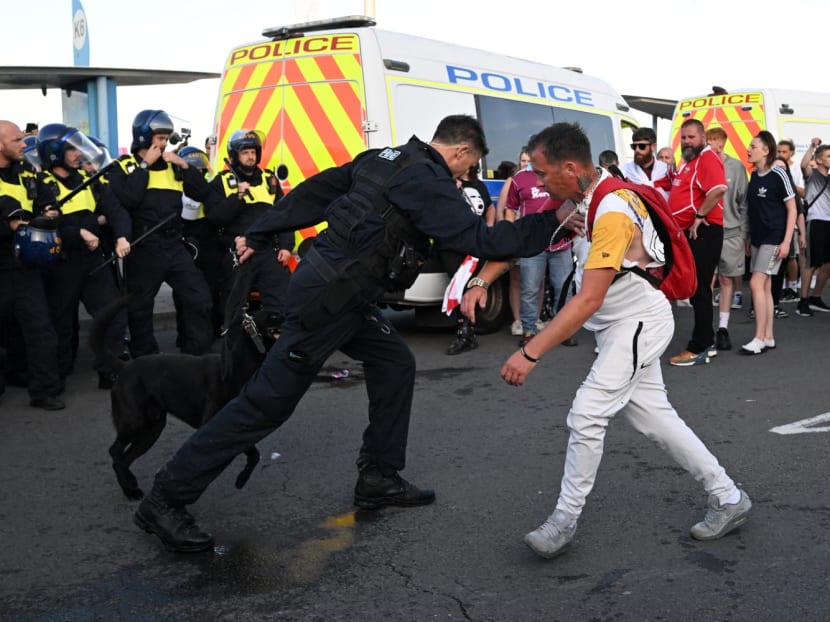 A police officer restrains a protester during a demonstration called by far-right activists in Weymouth, on the southwest coast of England where a migrant accommodation barge is moored, on Aug 4, 2024. A police officer restrains a protester during a demonstration called by far-right activists in Weymouth, on the southwest coast of England where a migrant accommodation barge is moored, on Aug 4, 2024.