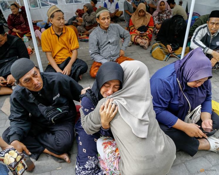 Relatives weep for scores of missing children after deadly Indonesia school collapse
