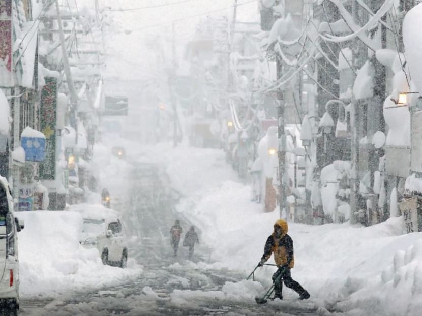 People remove snow on a street in Yuzawa, Niigata Prefecture, Japan in this photo taken by Kyodo Dec 17, 2020. 
