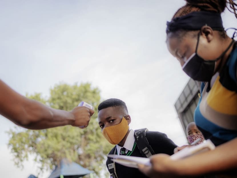 A student from Ithute Higher Primary School is screened, during the first day of the new academic year by school staff, in Alexandra, Johannesburg, on Feb 15, 2021.