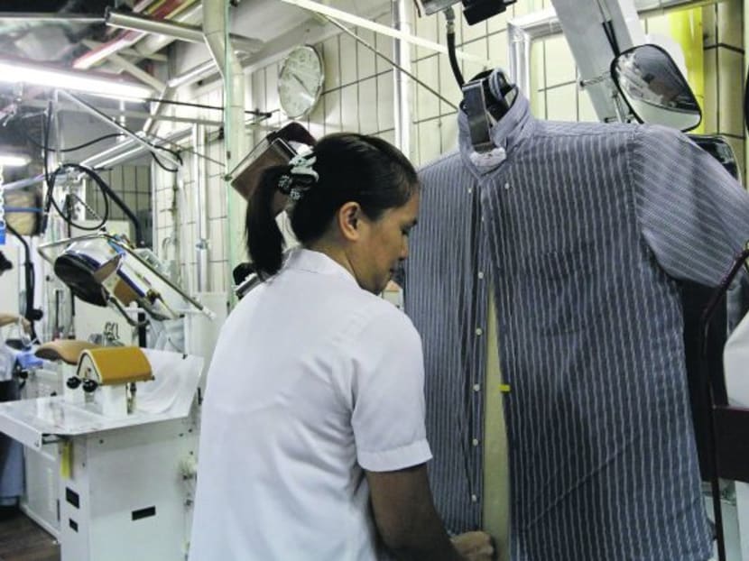 Sheraton Towers Hotel worker using an automated shirt pressing machine. Photo: Don Wong