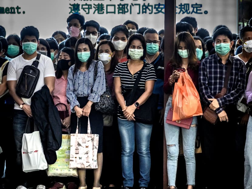 Commuters with protective facemasks wait to board a canal boat at Pratunam Pier in Bangkok on Jan 30, 2020.
