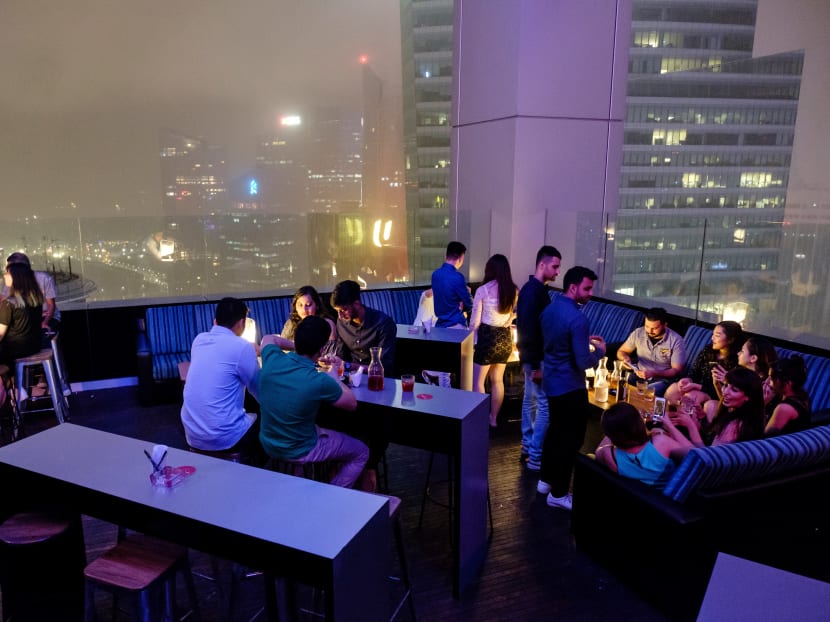 Guests at the Skyline bar in Singapore. The Skyline, a Singapore bar that bills itself as the world's highest cryptocurrency club, is offering a New Year's Eve package that includes a limousine pick-up and butler service - but it'll cost you a whole Bitcoin. Photo: AFP
