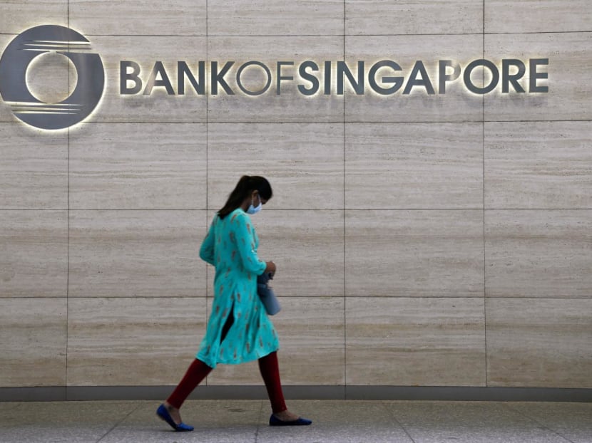 A woman walks past a Bank of Singapore office in Singapore on March 31, 2022. A woman walks past a Bank of Singapore office in Singapore on March 31, 2022.