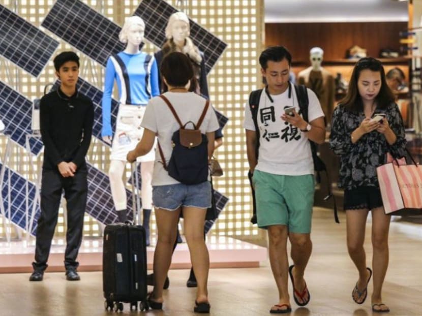 Shoppers exiting Louis Vuitton at Times Square in Causeway Bay, Hong Kong. Many consumers choose to make their purchases while travelling overseas.
