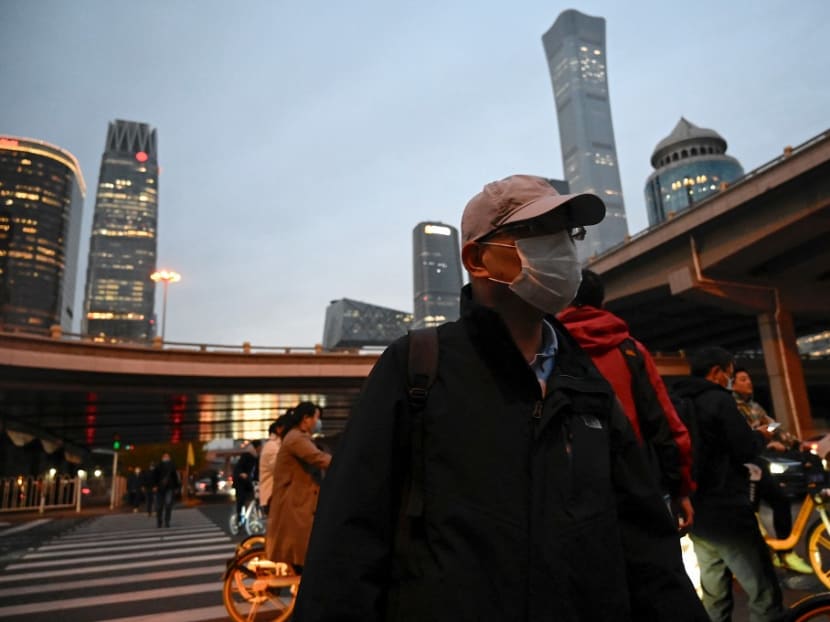A man crosses a road at an intersection in Beijing on Oct 28, 2021.
