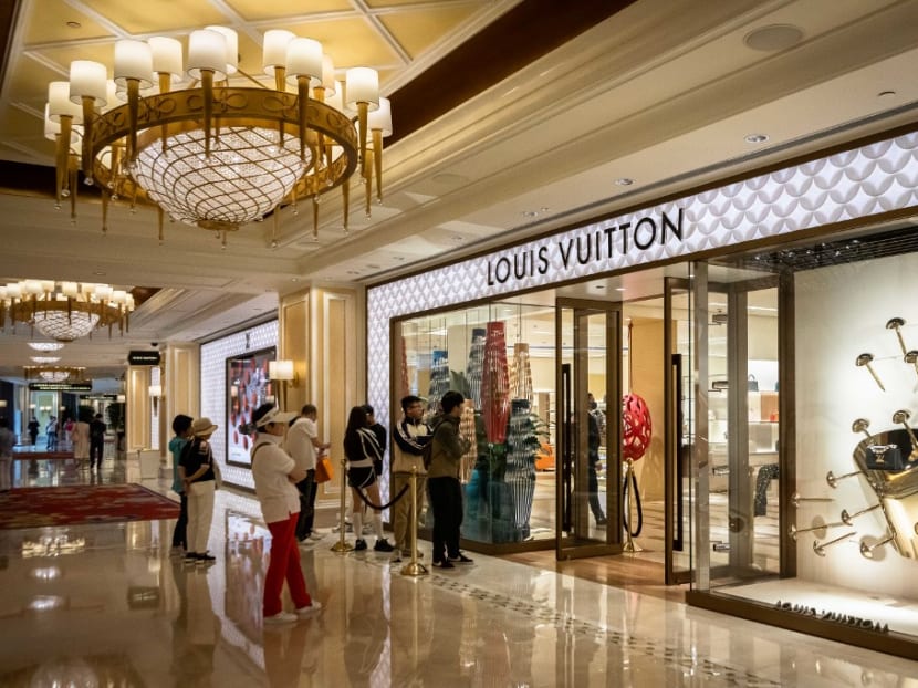 A photo taken on March 9, 2023 shows visitors queuing outside a Louis Vuitton shop at the Wynn hotel resort in Macau.