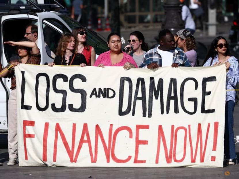 FILE PHOTO: Environmental activists hold a banner with the slogan "Loss and damage, finance now" during a climate strike action at the Place de la Republique, on the sidelines of the New Global Financial Pact Summit, in Paris, France, June 23, 2023. REUTERS/Stephanie Lecocq/File Photo