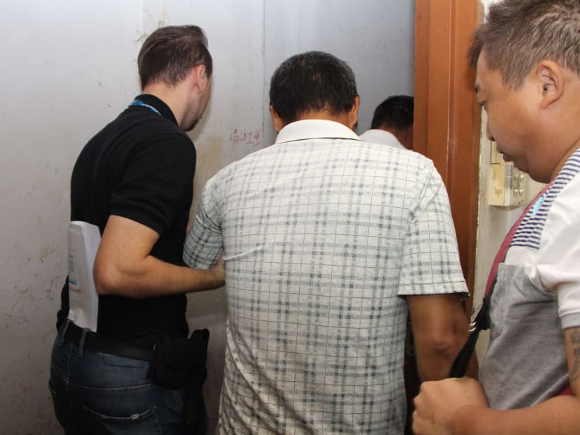 A man suspected of profiting from the importation of illegal workers is arrested. Photo: Ministry of Manpower file photo