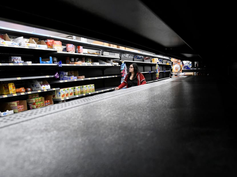A woman shops for last minute supplies while shelves remain empty as Hurricane Lane approaches Honolulu.
