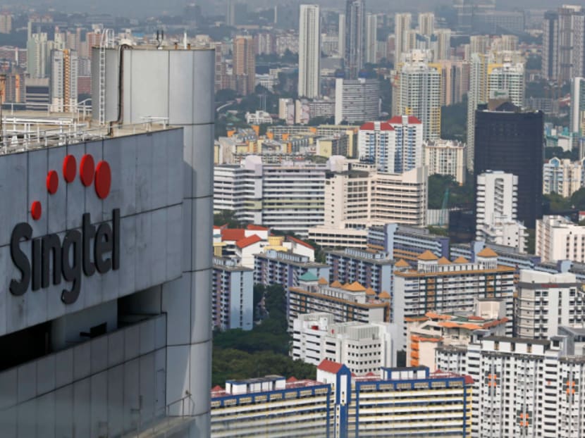 A Singtel logo is pictured in the backdrop of public housing estates in Singapore's central business district February 11, 2015. Photo: Reuters