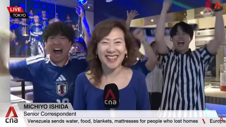 Japan fans celebrate as the team progresses to the World Cup knockout stage