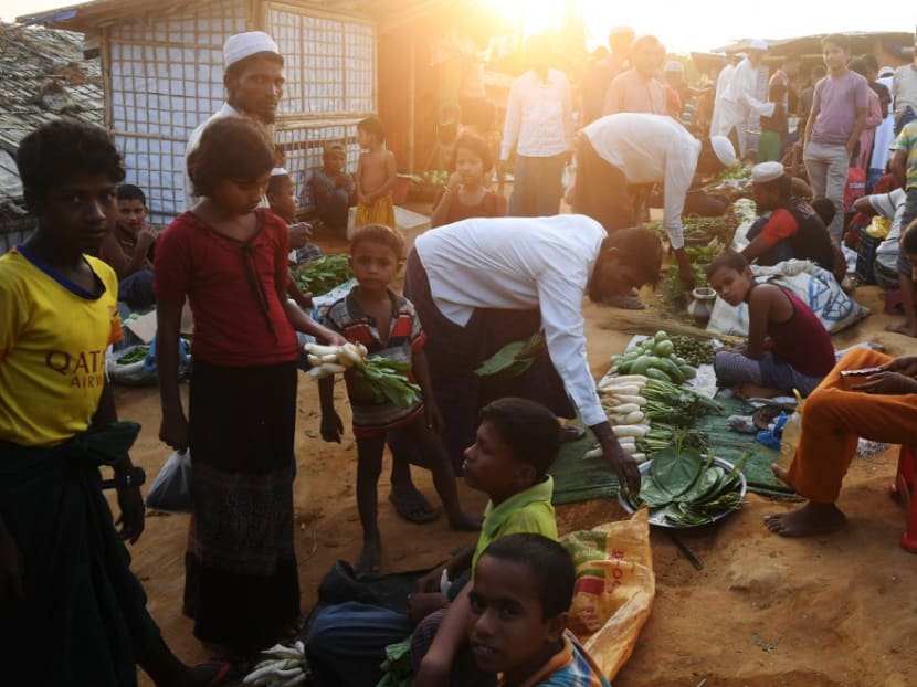 Rohingya refugees bargain for items at the Hakimpara refugee camp in Bangladesh's Cox's Bazar district on November 18, 2018.
