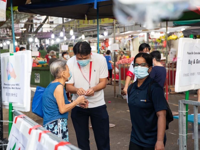 A market-goer gets her NRIC number checked at about 7.30am on April 23, 2020, before entering a wet market at Block 505 Jurong West Street pictured here. A market-goer gets her NRIC number checked at about 7.30am on April 23, 2020, before entering a wet market at Block 505 Jurong West Street pictured here.