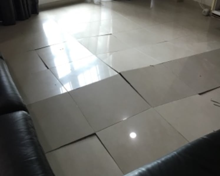 What causes floor tiles to suddenly pop