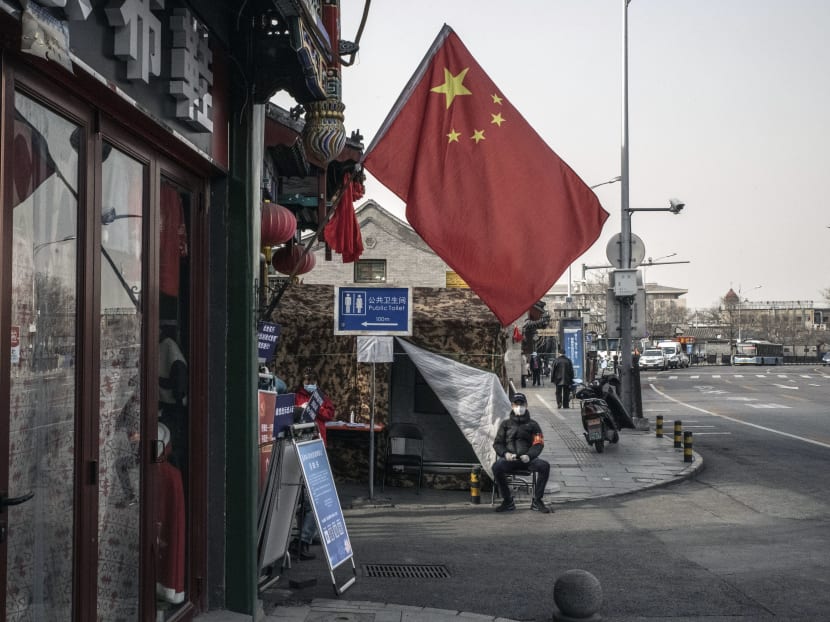 A guard on March 18, 2020, at the entrance of a checkpoint in Beijing where neighborhood residents must show they are healthy.