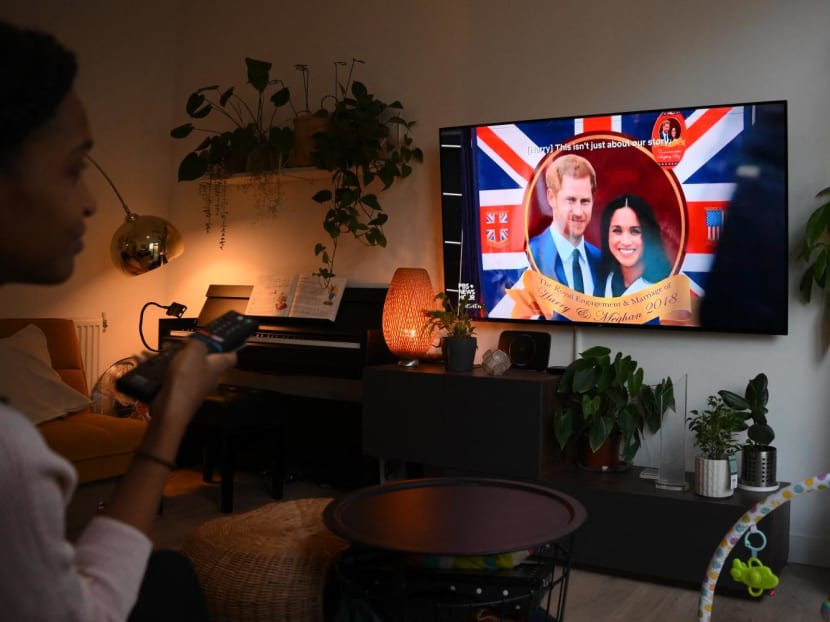 A woman poses as she watches an episode of the newly released Netflix docuseries "Harry and Meghan" about Britain's Prince Harry, Duke of Sussex, and Britain's Meghan, Duchess of Sussex, in London on Dec 8, 2022. 
