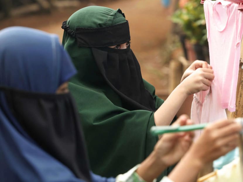 Indonesian women with face-concealing niqab headdress hang clothes out to dry. The rector of Sunan Kalijaga State Islamic University banned full niqab head coverings this month, saying they were not a natural part of Indonesian culture. But after days of protests, he dropped the ban. Photo: Reuters