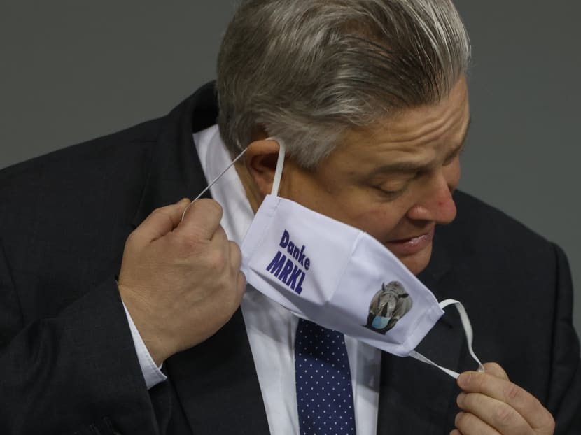 German MP Thomas Seitz takes off his face mask bearing the inscription "Thank you MRKL" (referring to Chancellor Angela Merkel) before speaking during a session at the Bundestag (lower house of parliament) in Berlin on Oct 30, 2020.