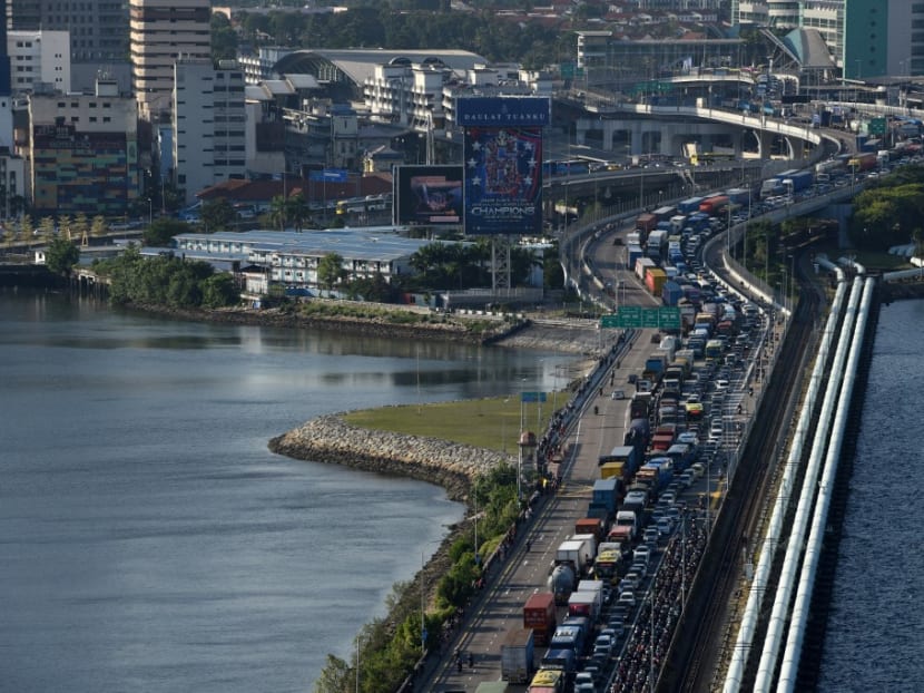 Vehicles form a long queue to enter Woodlands checkpoint in Singapore on March 17, 2020 from across the causeway of the southern Malaysian state of Johor. Vehicles form a long queue to enter Woodlands checkpoint in Singapore on March 17, 2020 from across the causeway of the southern Malaysian state of Johor.