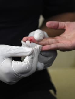 A medical worker extracts blood from a woman during a HIV test. 