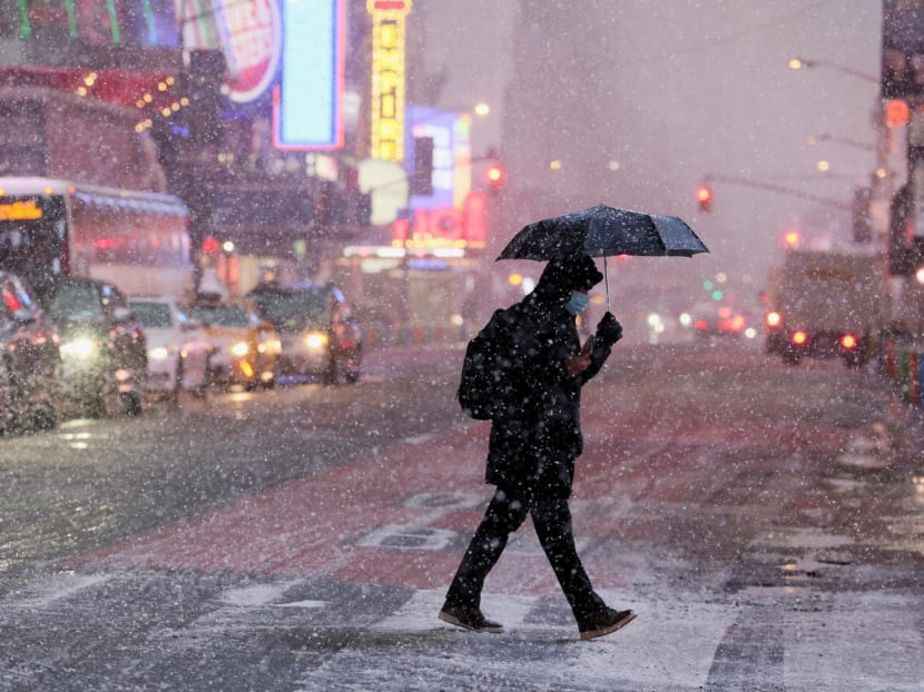 A morning commuter walks through wind and snow during a Nor'easter winter storm in the Times Square area in New York City, US, Feb 13, 2024.