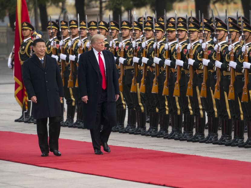 President Donald Trump, accompanied by President Xi Jinping of China, reviews an honour guard during a welcome ceremony in Beijing in November 2017. The author says that China, now competing with the US for global economic dominance, is desperately hard to read.